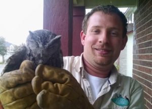 Wildlife removal technician holding an owl